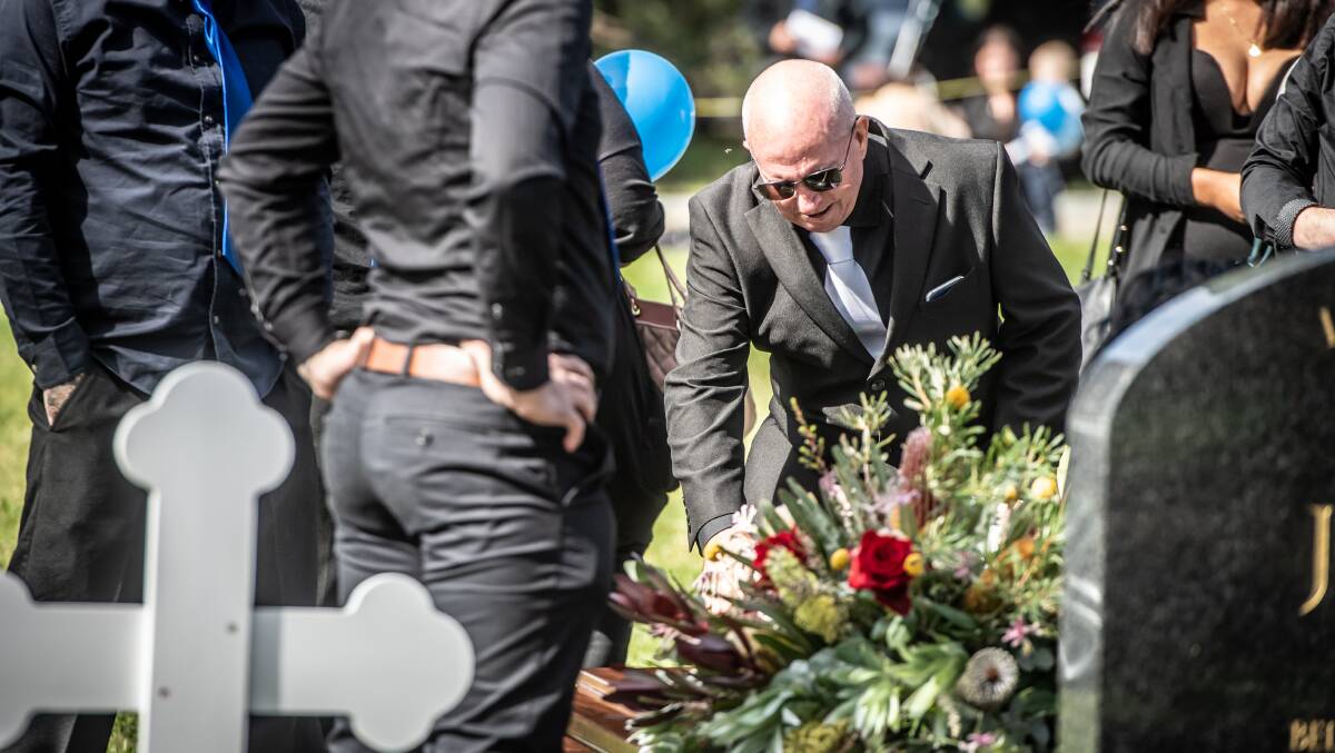 Peter Humphries over his son's coffin. PIcture: Karleen Minney