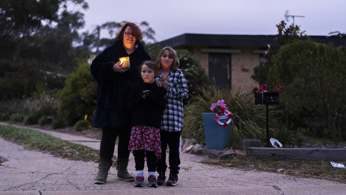 Ngaire Harvey, with Imogen and Aisha Harvey, stand in front of their Kambah home on Anzac Day. Picture: Dion Georgopoulos