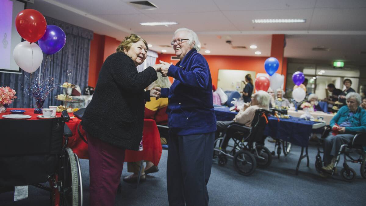 Residents Wendy Poole and Colleen Wilson dance to music at Southern Cross Aged Care at a high tea in preparation for Mother's Day. Picture: Dion Georgopoulos