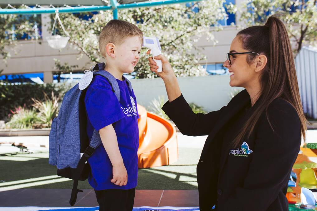 Papilio Early Learning Barton has been checking children's temperatures before they can enter the centre. Centre Manager Katelyn Pollard, with two-year old Zac Carter.
Picture: Jamila Toderas 
