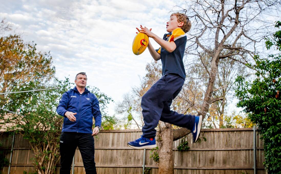 Dr John Williams, UC assistant professor in physical education has found some innovative ways to teach from home. Pictured with son Jack , 9.Picture: Elesa Kurtz 