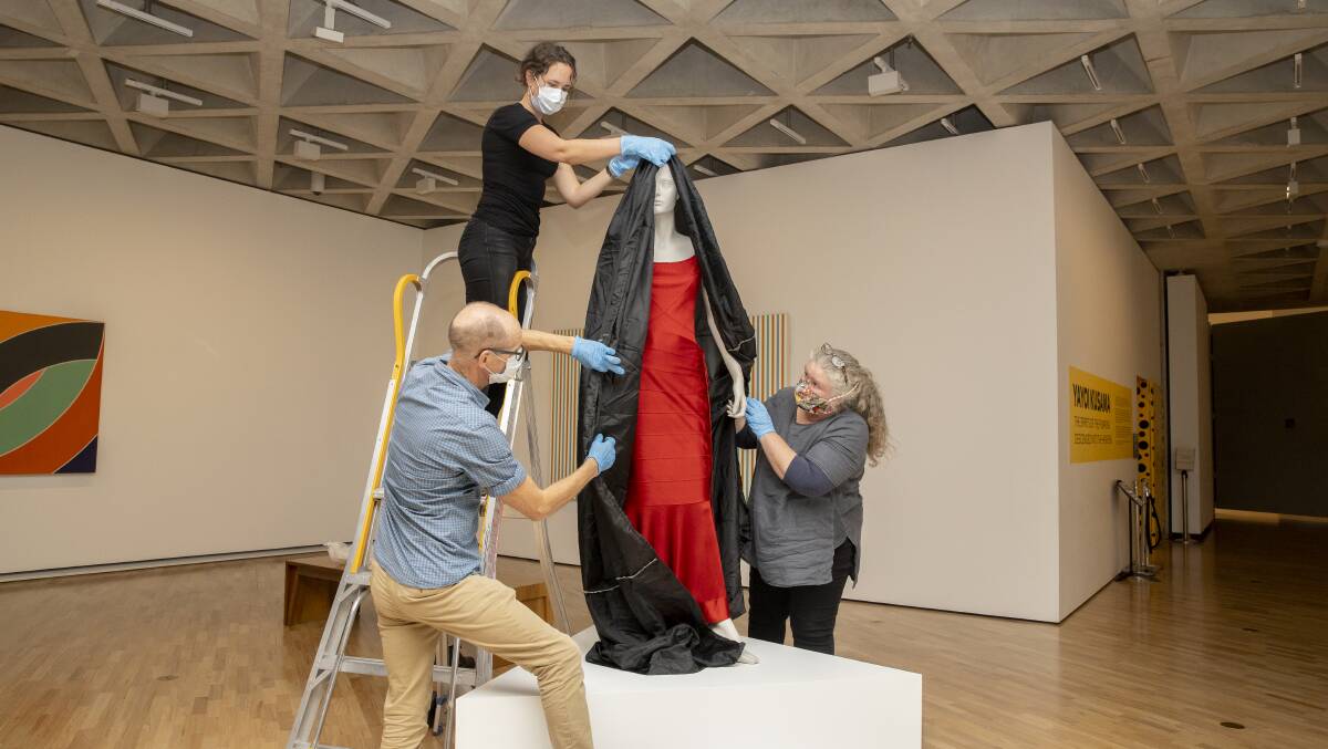 Conservators work on the Pop and Op Art exhibit in preparation for the National Gallery of Australia's reopening on Tuesday. Picture: Sitthixay Ditthavong