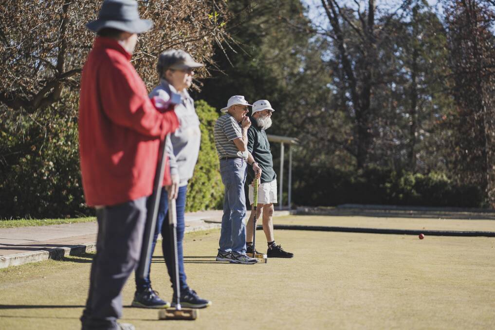 Croquet players wait on their opponents' moves on the Canberra Croquet Club's lawns on Saturday. Picture: Dion Georgopoulos