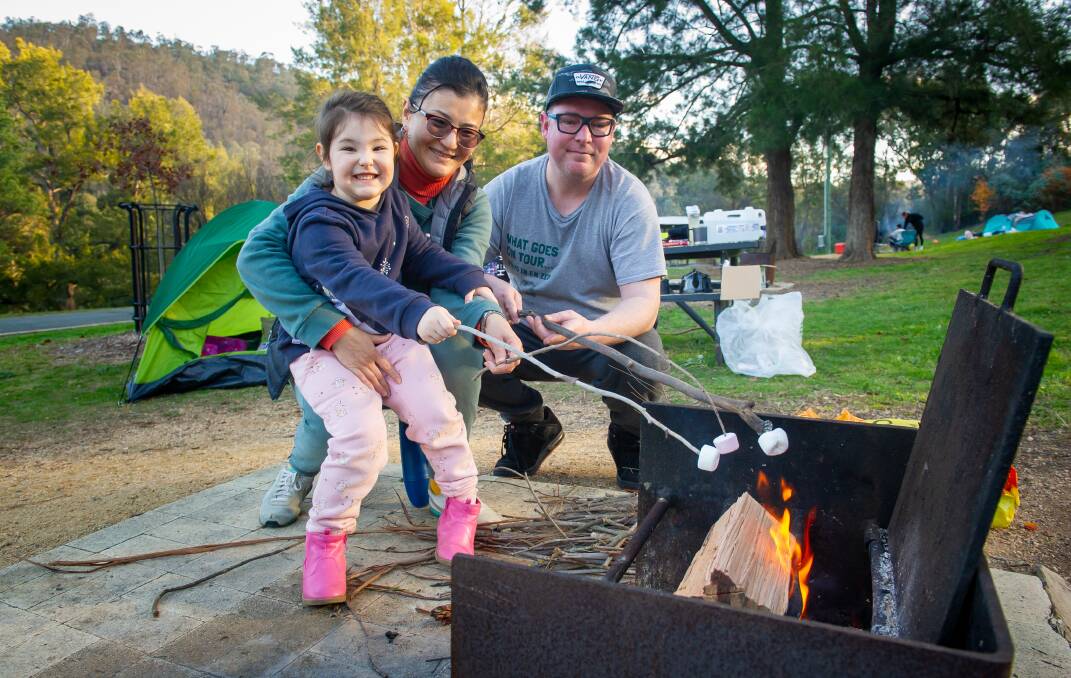 Amelia Williams, 4, with mum Svyeta Daribai and dad Craig Williams roasting marshmallows at Cotter Campground. Picture: Elesa Kurtz 