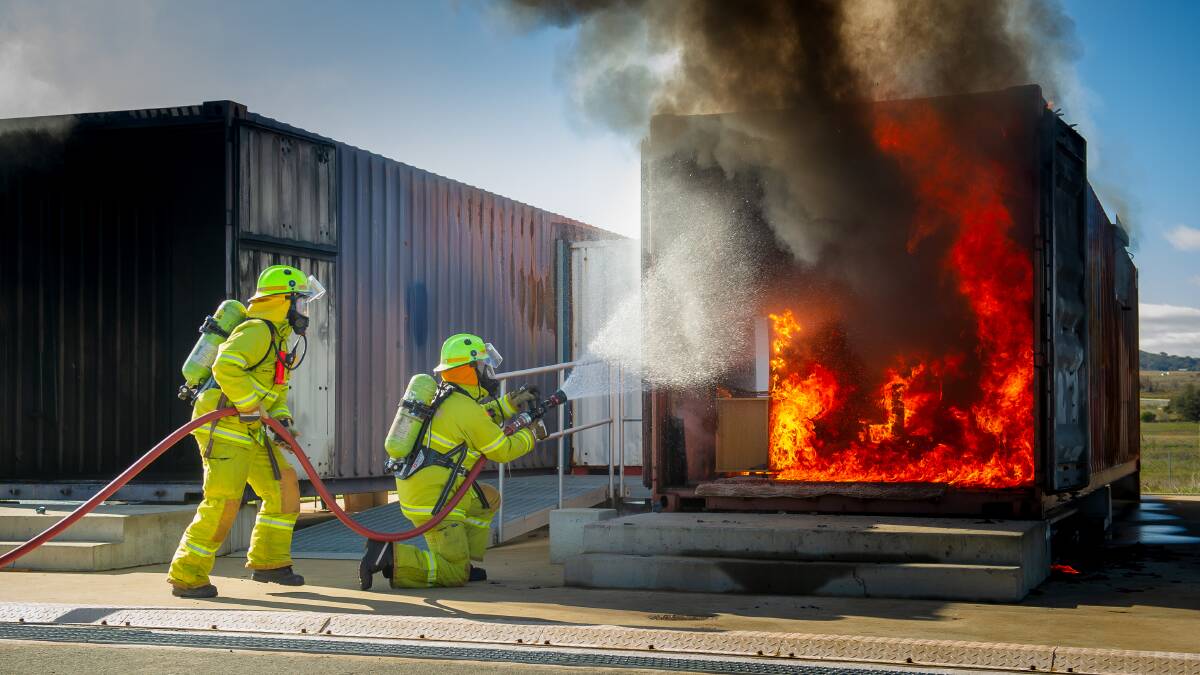 ACT Fire and Rescue senior firefighters Kate Judd and Brad Bray in demonstration during launch of Winter Home fire safety campaign. Picture: Elesa Kurtz