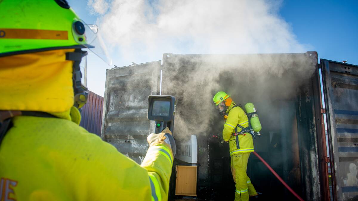 ACT Fire and Rescue senior firefighters Kate Judd and Brad Bray in demonstration during launch of Winter Home fire safety campaign. Picture: Elesa Kurtz