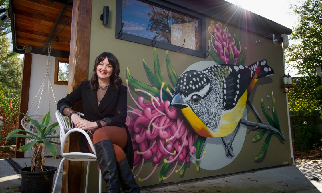 Tracey Davis at her Aranda home with the mural by the Canberra artist Smalls. Picture: Elesa Kurtz 