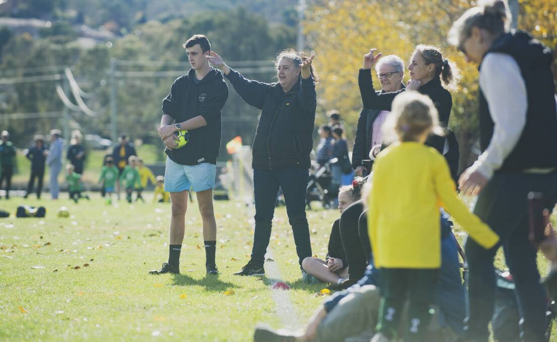 Parents support their kids from the sideline at a MiniRoos match.
