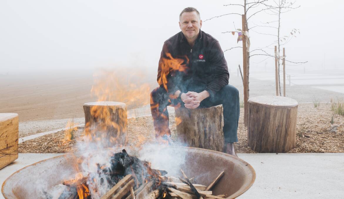 The general manager of Canberra Park, David Grigg, sits by a fire pit at the newly developed caravan park on Old Well Station Road. Picture: Jamila Toderas