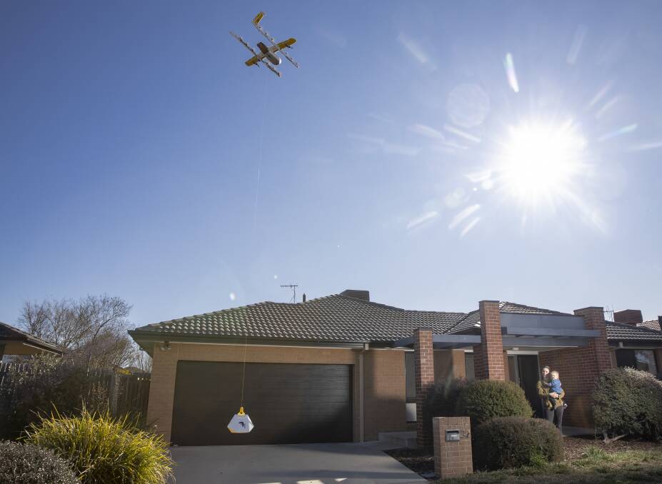 Naomi Le Lievre and her 18-month-old daughter Jasmine receive a drone-delivered toastie at their Franklin home. Picture: Sitthixay Ditthavong 