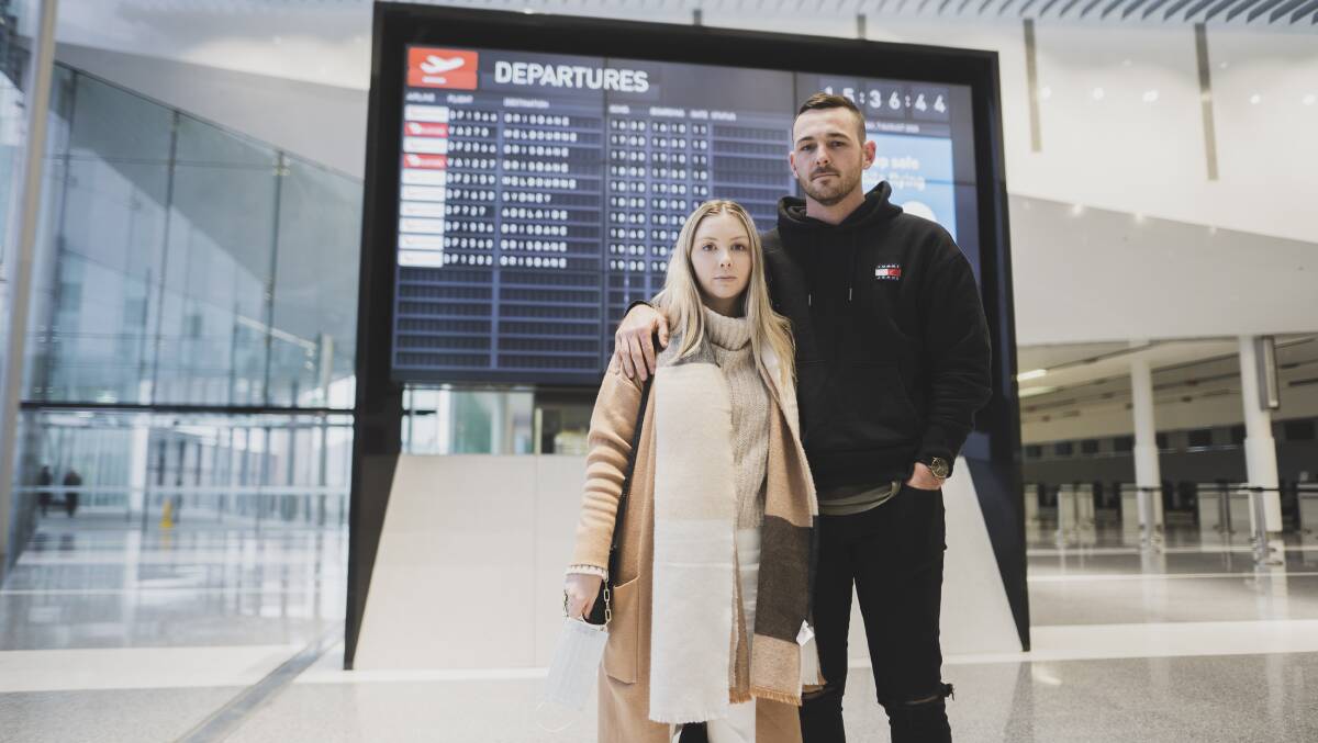 Amelia Donaldson, who was flying back to Brisbane to avoid border closures, with her partner Christian Wilson at Canberra Airport. Picture: Dion Georgopoulos 