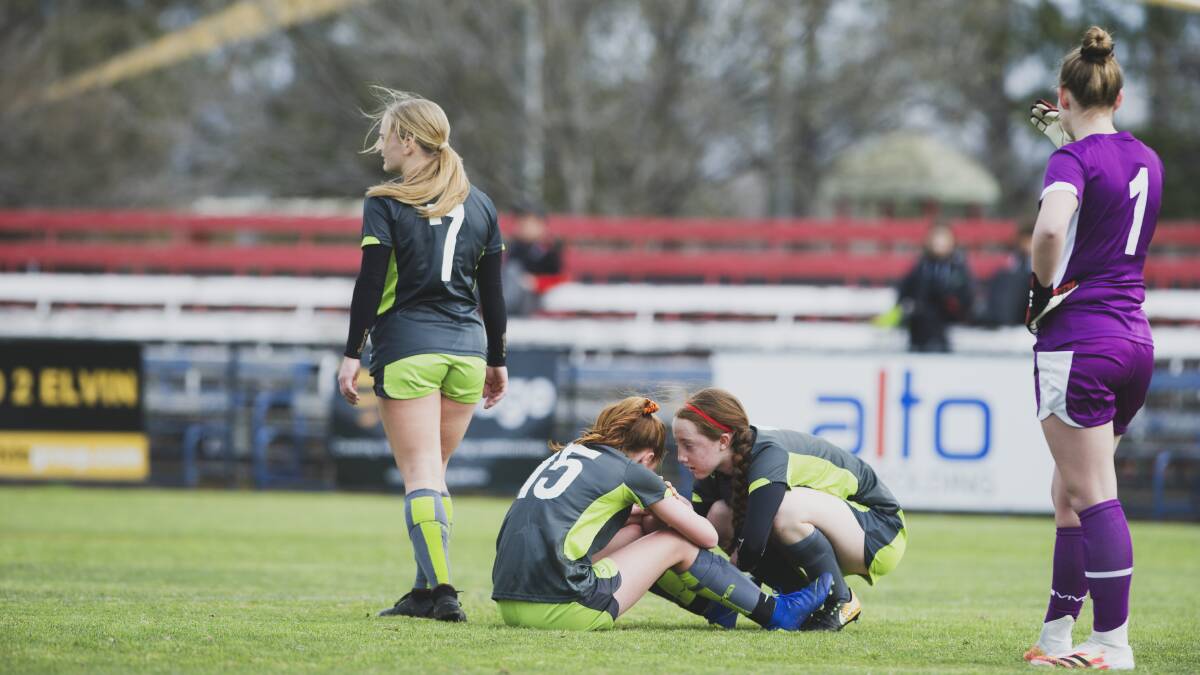 Katherine Tyo sits injured as Annaliese Grove comes to her aid. Picture: Dion Georgopoulos