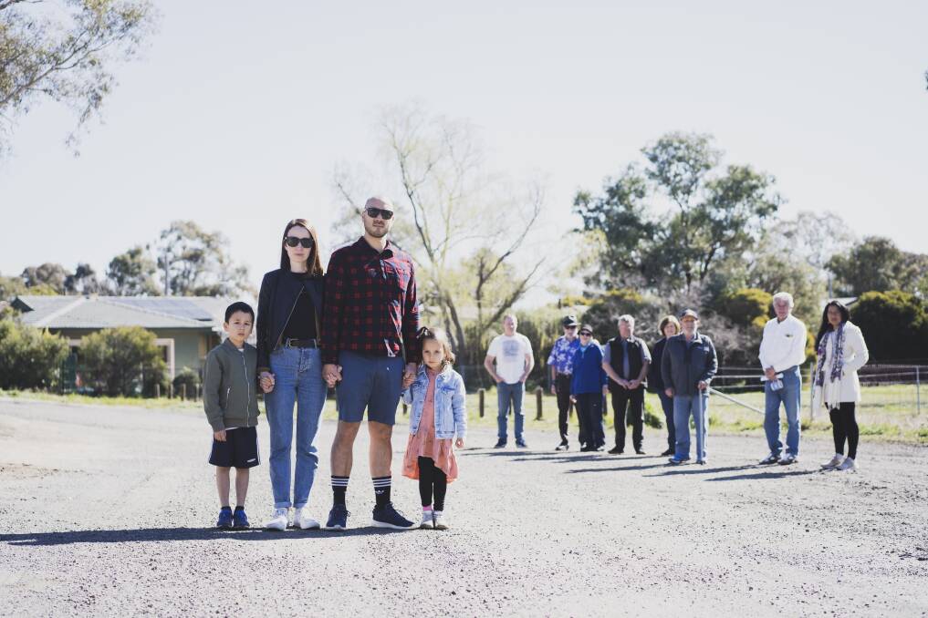 Alan and Julia Larby, front, with Harrison, 7, and Violet, 5, join other Fraser residents and Liberal member for Ginninderra Elizabeth Kikkert, far right, at the expanded terminus on Saturday. Picture: Dion Georgopoulos
