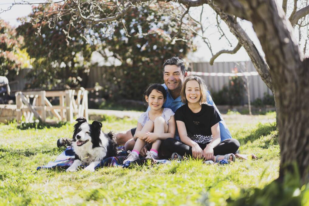 Chris Hart with his daughters Lily, eight, and Georgie, nine, at their home in Farrer, with Gem the dog. Picture: Dion Georgopoulos