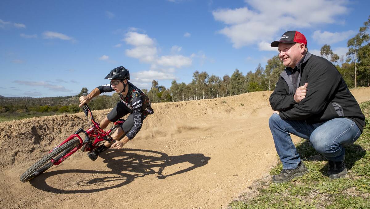 Canberra Off-Road Cyclists vice-president Darrent Stewart watches on as mountain biker Jackson Frew tackles a trail at Stromlo Forest Park. Picture: Sitthixay Ditthavong