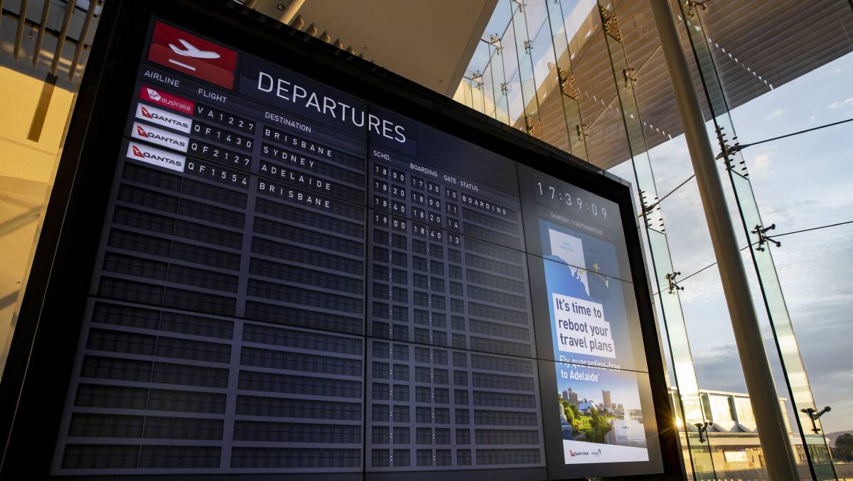 The main departures board at Canberra airport lists the first direct Canberra to Adelaide flight since South Australia opened its border to the ACT. Picture: Sitthixay Ditthavong