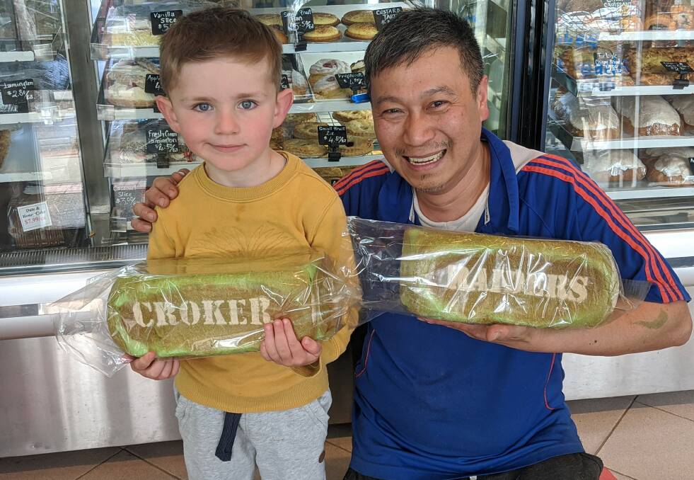 Samuel Dewar, four, of Mawson with his loaf of Croker bread with Vina Bakehouse and Coffee Shop owner Quan Nguyen who has created peak Raiders bread. Pictures: Megan Doherty