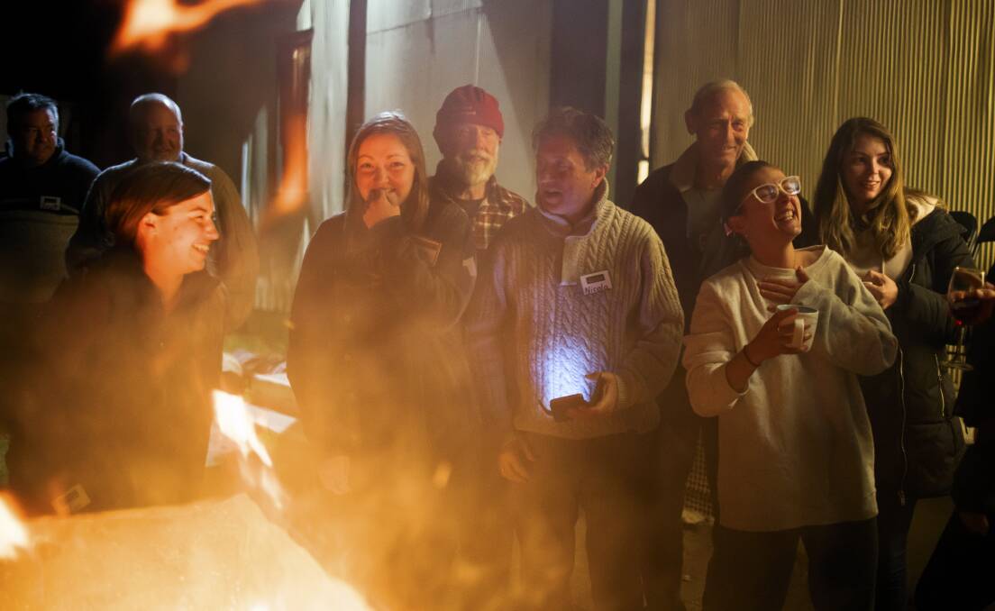 Volunteers gather around the fire at camp in Braidwood. Picture: Sitthixay Ditthavong 