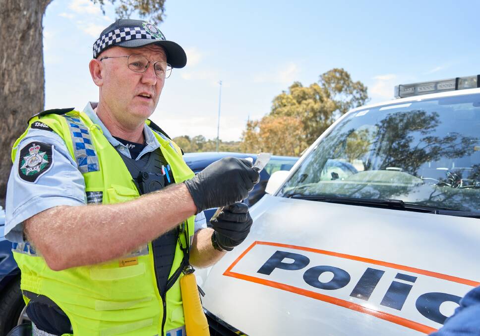 Senior Constable Simon Hackett, from ACT Traffic, administrating a mouth swab roadside drug test to detect cannabis and methamphetamines. Picture: Matt Loxton.