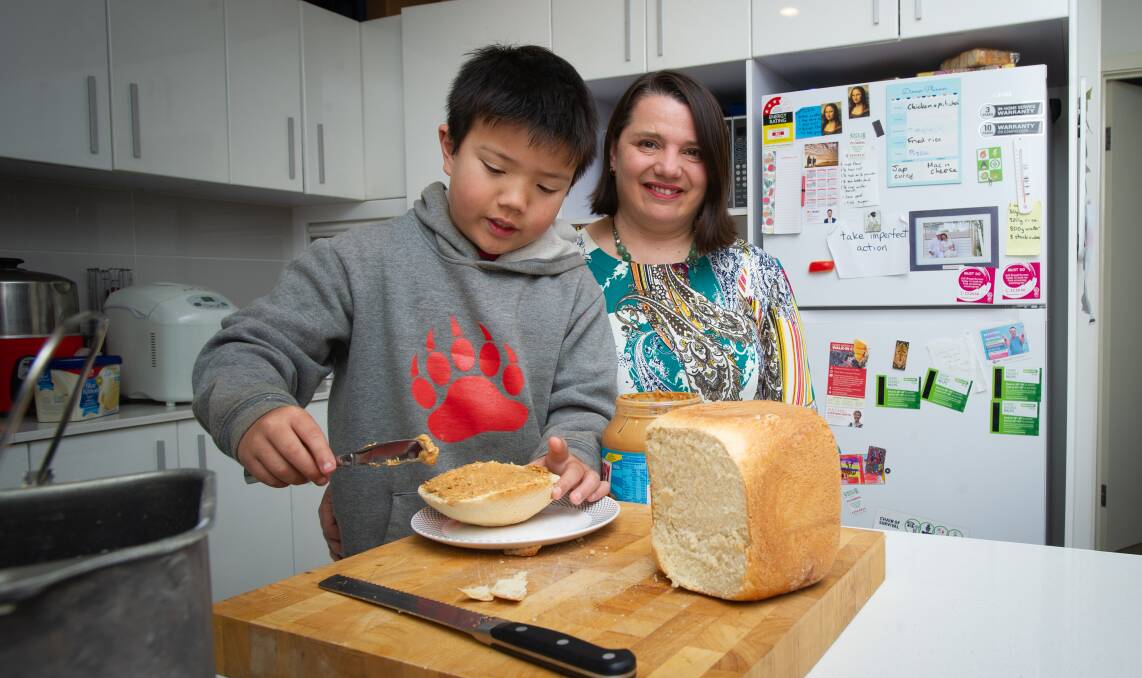 Audie Huang eats homemade bread by mum, Serina Bird, who will be giving a workshop on living frugally at the Canberra Zero Waste Festival. Picture: Elesa Kurtz 