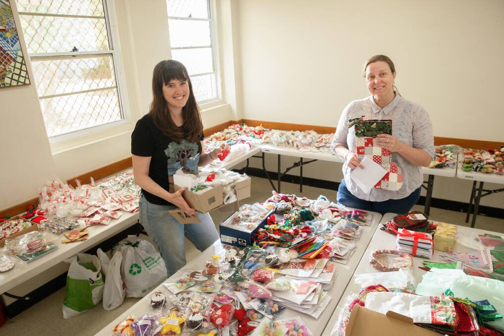 Canberra friends Juanita Watters and Bianca Brownlow pack Christmas decorations for families who lost theirs during the bushfires. Picture: Sitthixay Ditthavong 