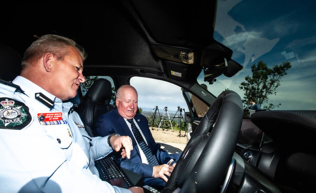 The officer in charge of road policing, Detective Inspector Marcus Boorman, shows Police and Emergency Services Minister Mick Gentleman some of the technology inside the new BMW X3 police vehicles. Picture: Karleen Minney