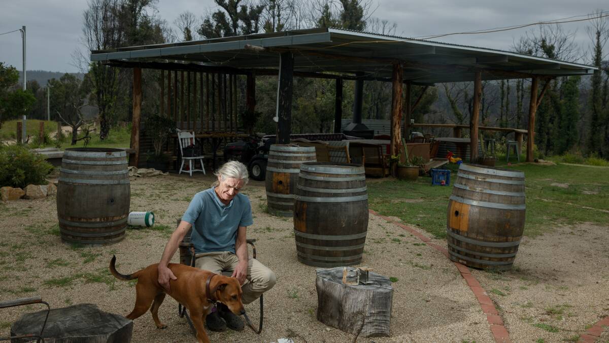 Michael Weekes in front of the Phoenix Bar with his dog Jinni, nearly a year after he battled the Currowan fire that threatened his Woodburn property. Picture: Sitthixay Ditthavong