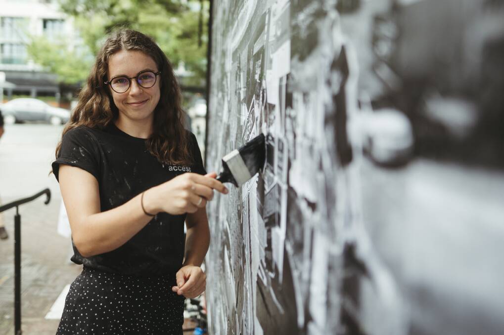 PhotoAccess lead mural artist Kate Matthews at the Faces of Braddon mural on Mort St. Picture: Dion Georgopoulos