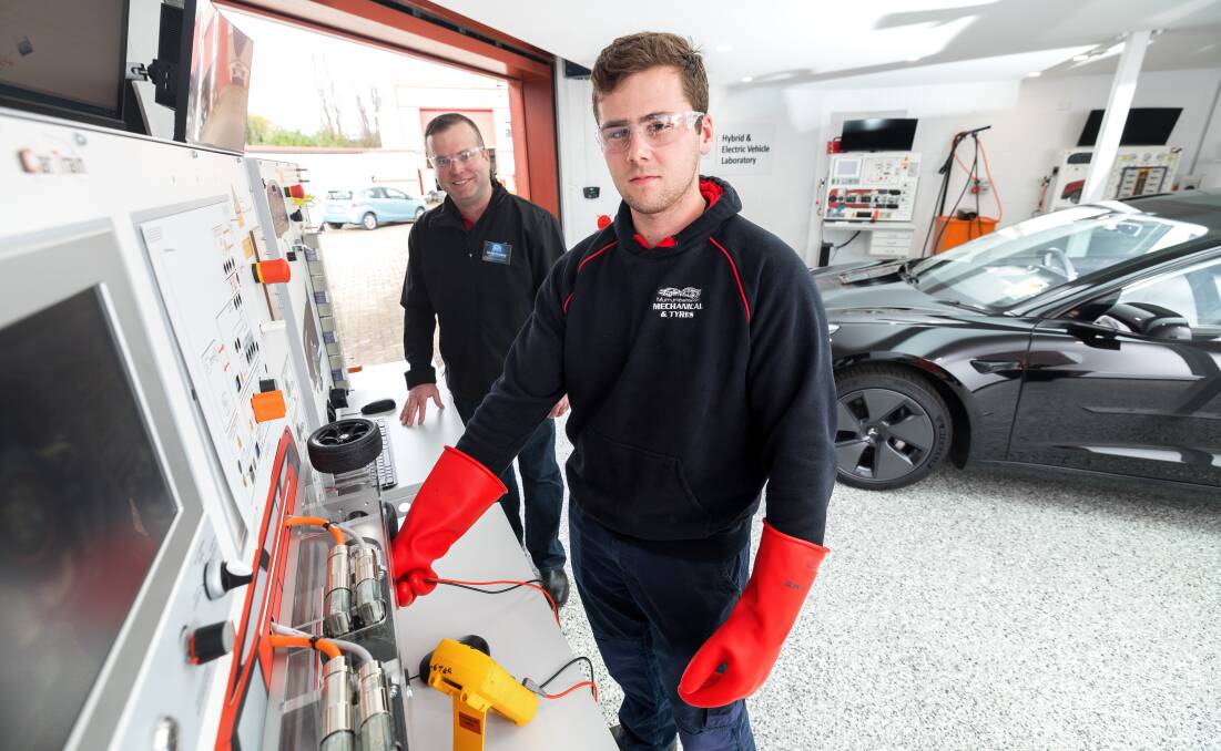 Richard Lindsay and Canberra Institute of Technology apprentice Harvey Blackmore go through diagnostic tools in the electric-vehicle workshop at the Fyshwick campus. Picture: Sitthixay Ditthavong