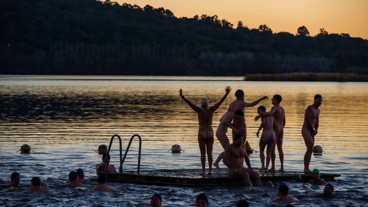 Brave swimmers celebrate the solstice as the sun comes up on Lake Burley Griffin. Picture: Karleen Minney