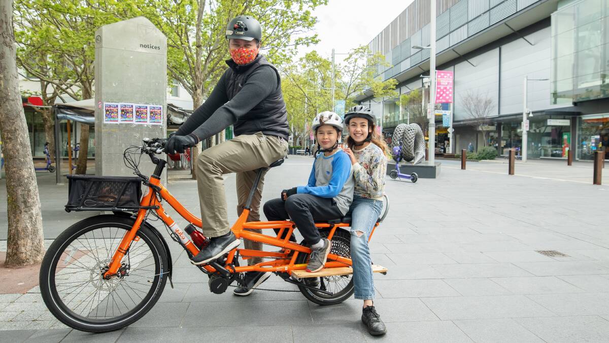 Brendan, Isoa and Indigo Chan loaned a bike from Canberra's electric bike library to take a spin around Civic. Picture: Sitthixay Ditthavong