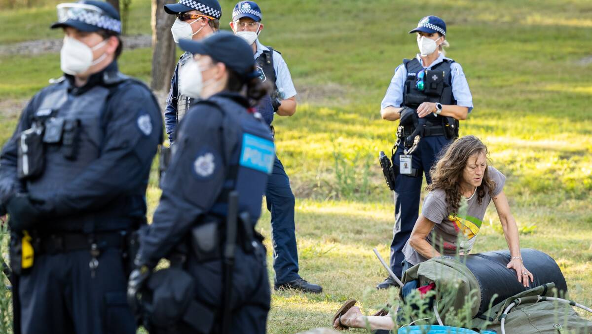 A protester packs up her belongings after police began clearing protesters from Cotter Campground on Monday evening. Picture: Sitthixay Ditthavong