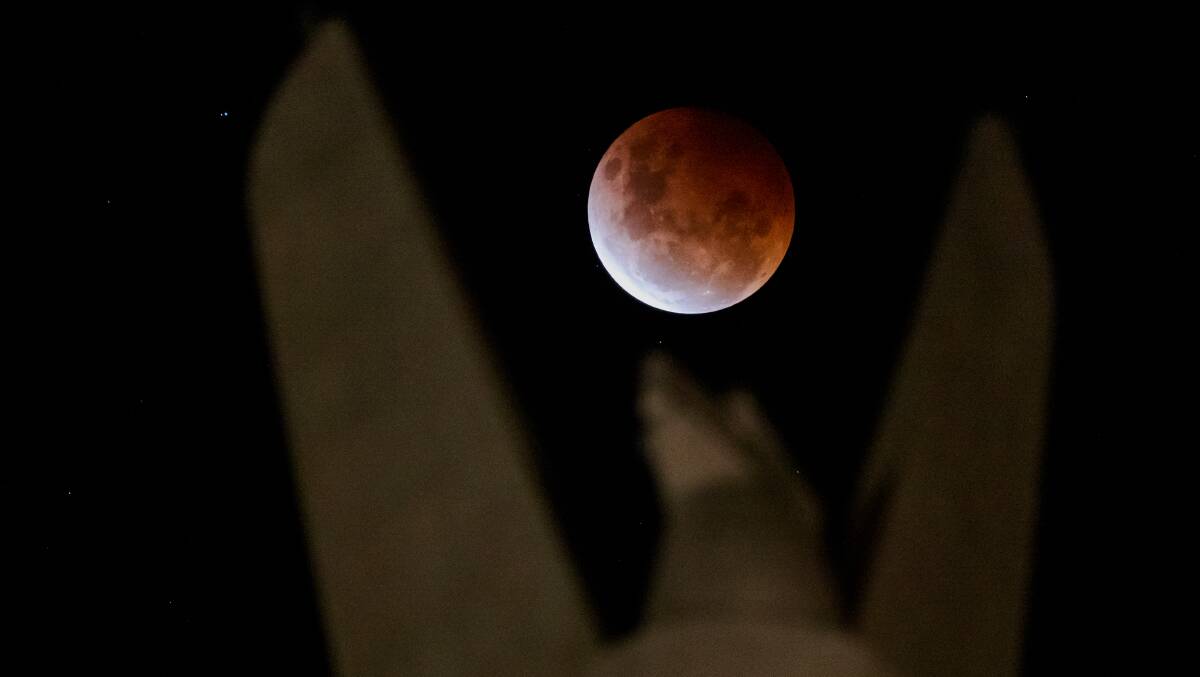 A Super Blood Moon was captured behind the Australian American Memorial in Russell. Picture: Sitthixay Ditthavong