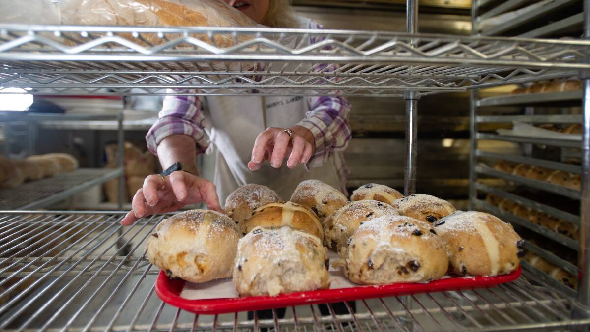 Katie Humphries helps prepare the Easter hot cross buns at Danny's Bakery in Narrabundah. Picture by Karleen Minney