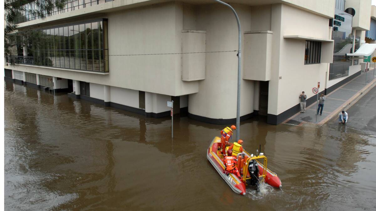 SES crew survey the scene flood waters around the Queanbeyan Leagues Club on Collett Street in December 2010. Picture by Graham Tidy