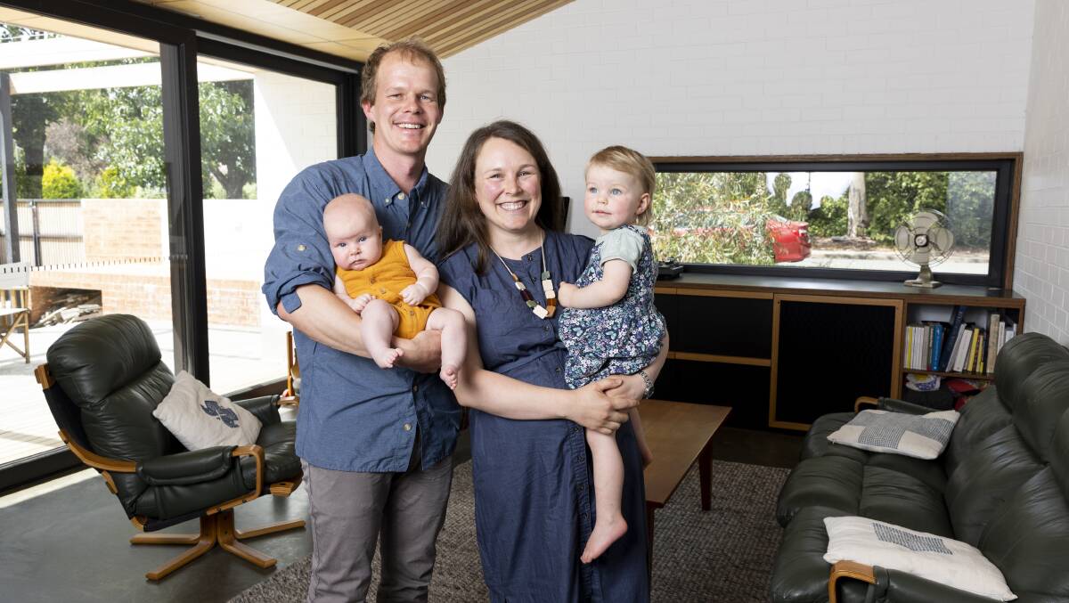 Watson home owners Mark Lavis and Hannah Lord, with their children Nora and Heidi Lavis inside the house they built themselves. Picture by Keegan Carroll