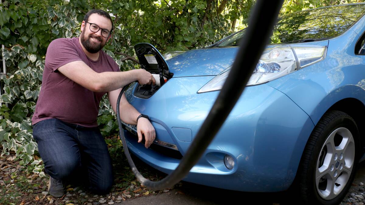 Derek James charging his electric vehicle from a new smart charger that has been installed at his home in Downer. Picture: James Croucher