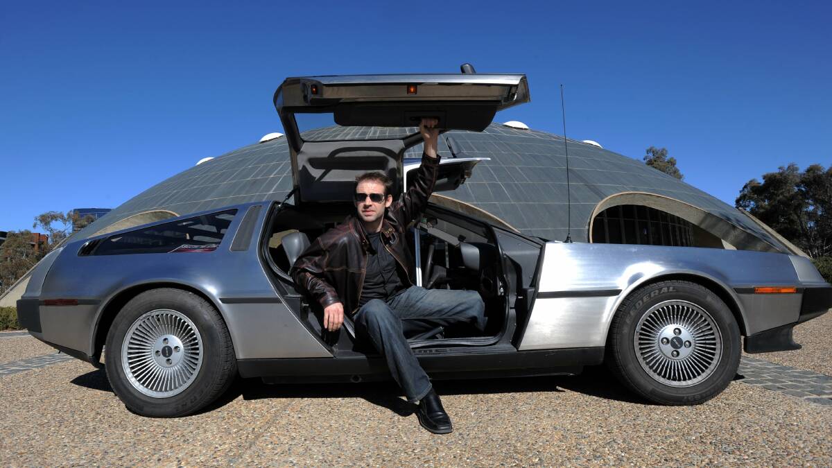 Che Baker with the DeLorean owned by friend and author, Matthew Reilly outside the Shine Dome. Picture: Graham Tidy