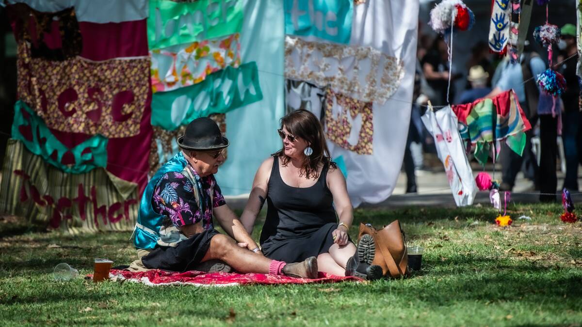 Ray Etherton of Rylestone NSW and Lisa Williamson of Hurstville soaked up the atmosphere under the bunting and flags of the 2022 National Folk Festival. Picture: Karleen Minney.