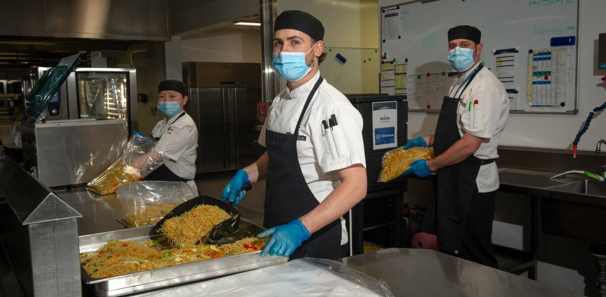 Department of Parliamentary Services catering and events staff Lynn Shen, Josh Brown and Charles Graham are preparing food to go to Vinnies' Blue Door during Canberra's lockdown. Picture: Elesa Kurtz