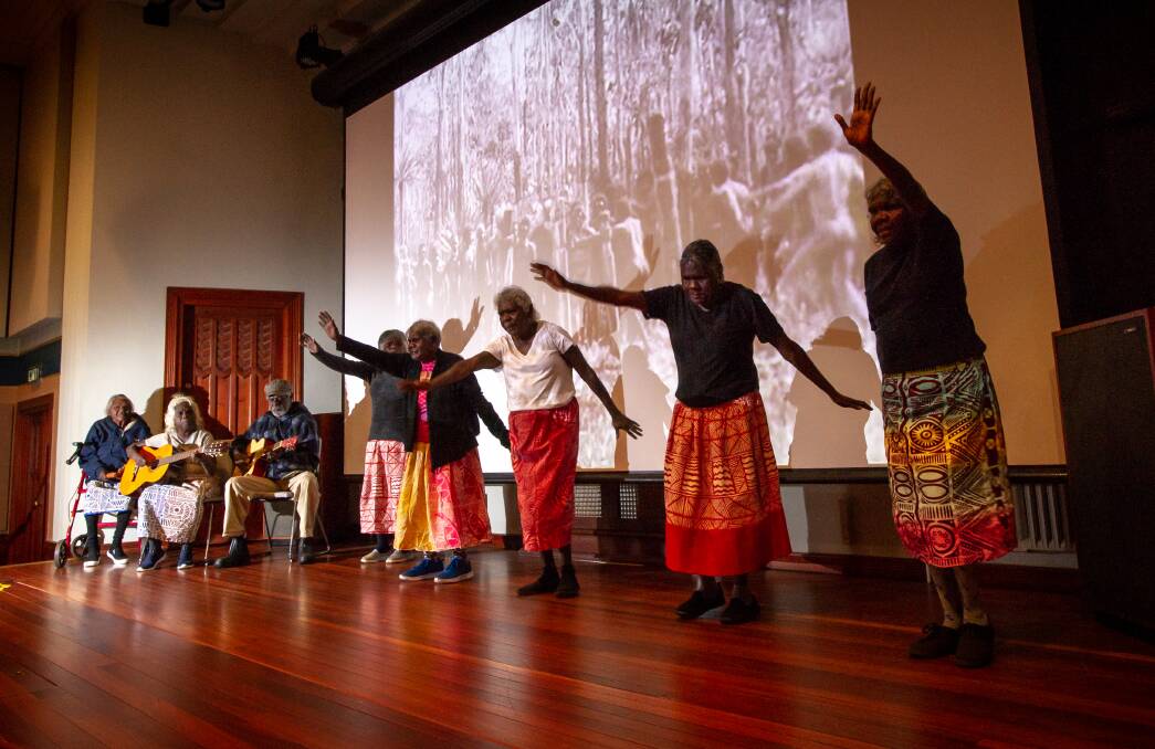 The Tiwi Strong Women performing in front of footage captured on Bathurst Island in 1912. Picture: Elesa Kurtz