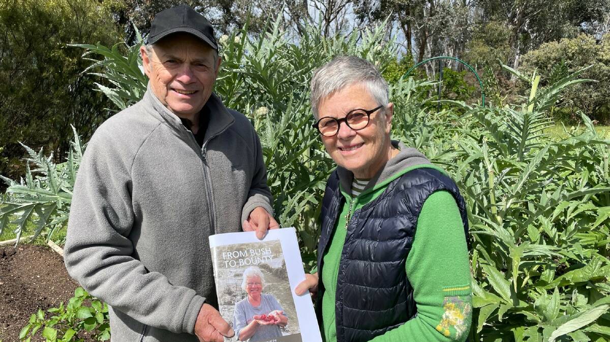 Peter Weddell and Julie Gorrell with the booklet celebrating 20 years of the Canberra Organic Growers Society Cook community garden. Picture: Richard Gorrell