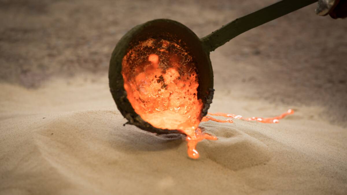Lindy Lee works with a ladle and melted bronze. Picture by Jean-Pierre Chabrol 
