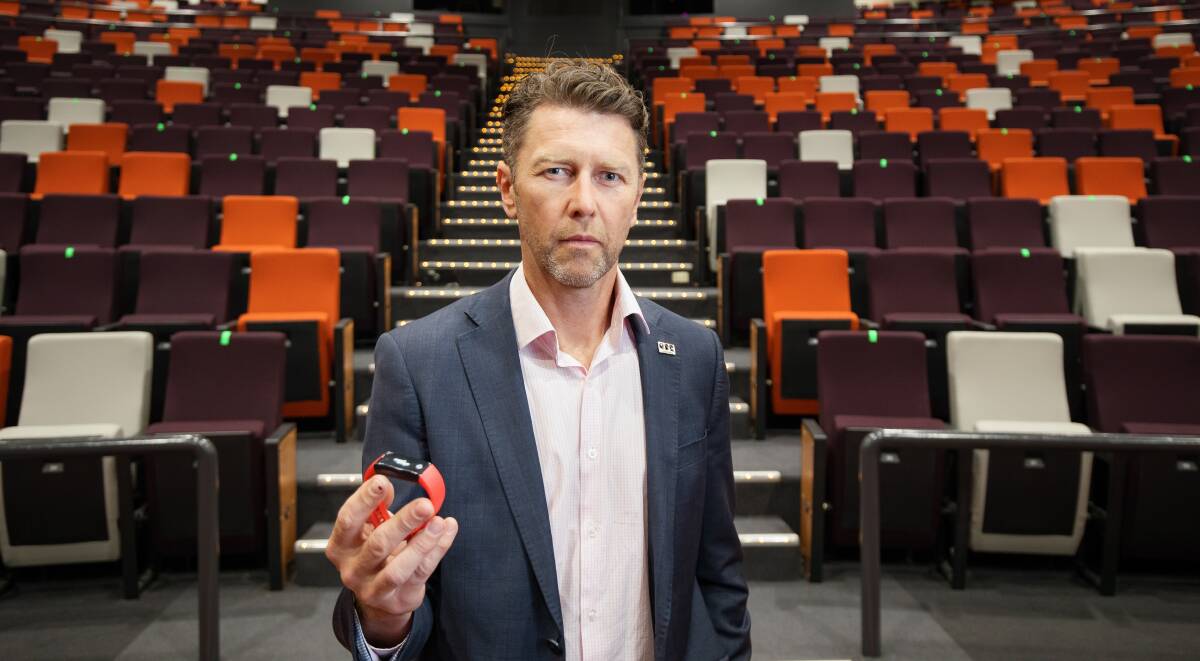 Canberra Convention Bureau boss Michael Matthews shows off prototypes of the Smart Badge technology. Picture: Sitthixay Ditthavong
