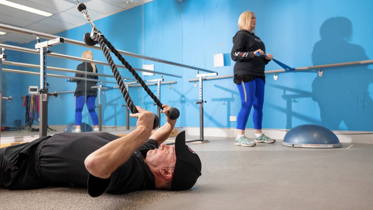Capital Region Muscular Dystrophy's Rob Oakley demonstrates a modified gym exercise while program particpant Michelle Anderson works with resistance bands. Picture: Sitthixay Ditthavong