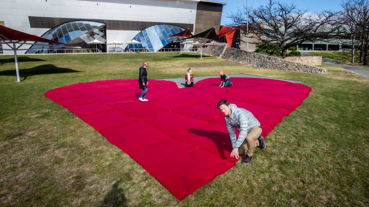 National Museum of Australia install a 15m x 13m heart made of red throw rugs for satellite selfie The rugs will later be donated to abandoned dogs. Picture: Karleen Minney