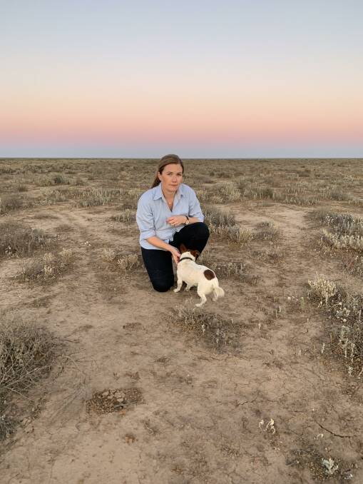 Alison McLean and her dog Gary in a paddock on her drought-stricken sheep farm 100 kilometres north of Hay. Picture: Supplied