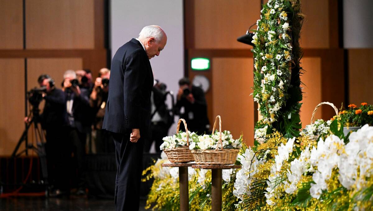 Former Australian prime minister John Howard lays flowers at a wreath during a 20th anniversary memorial of the Bali bombins held at Parliament house. Picture AAP