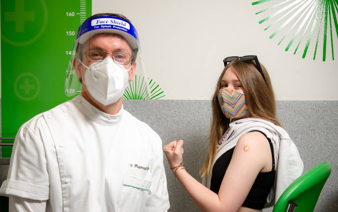 Pharmacist Nick Trevethan and Georgia Chesher, 15, helping Canberra flex its vaccination credentials. Picture: Elesa Kurtz