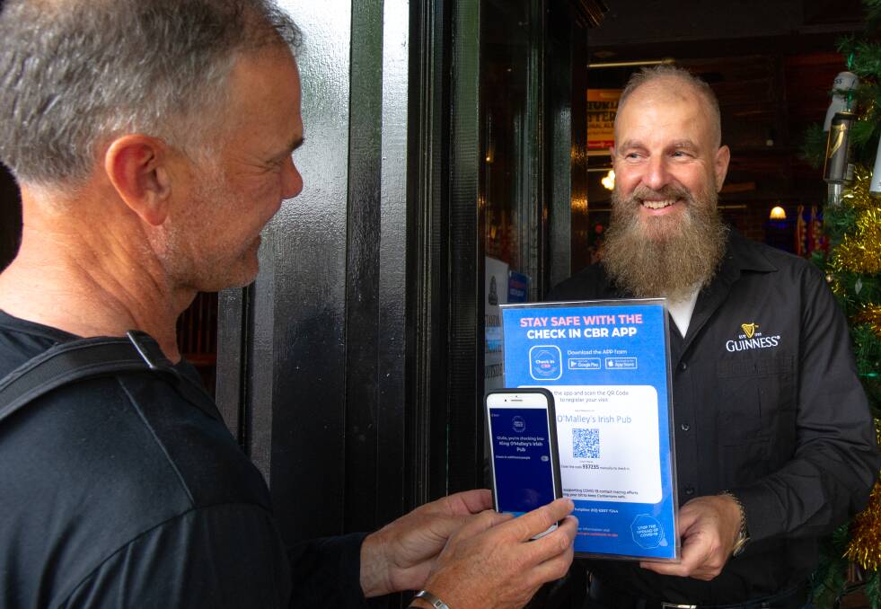 King O'Malley's owner Peter Barclay (right) signs in Giulio Cerasani using the pubs' QR code. Picture: Elesa Kurtz